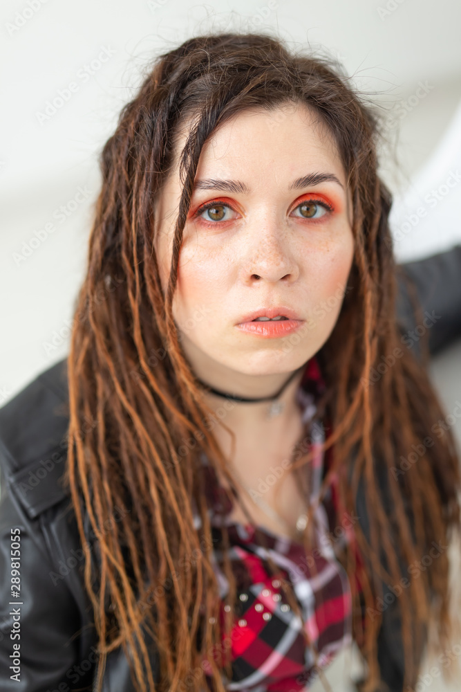 Fashion and beauty concept - young stylish woman in dreadlocks and colourful makeup Fashion and beauty concept - young stylish woman in dreadlocks and colourful makeup