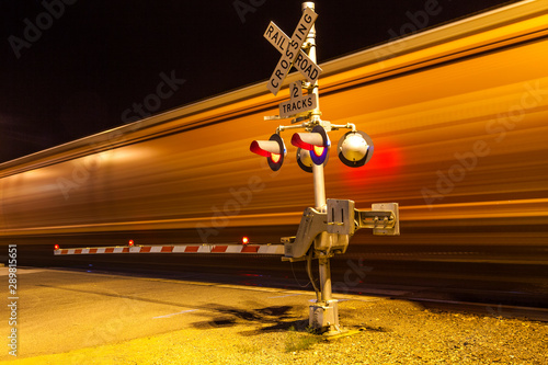 Billede på lærred train passes a crailway crossing by night at route 66
