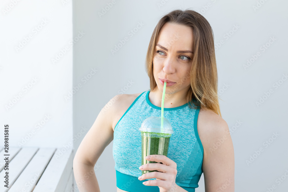 Healthy, sport, diet and people concept - Successful fitness urban woman recommending detox smoothie, close-up Healthy, sport, diet and people concept - Successful fitness urban woman recommending detox smoothie, close-up