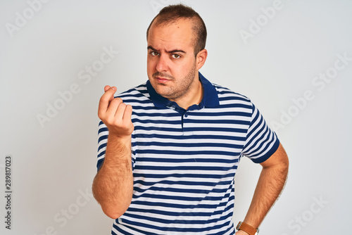 Young man wearing casual striped polo standing over isolated white background Doing Italian gesture with hand and fingers confident expression