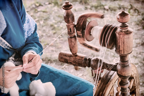 Vintage distaff creates threads from a spindle. Hand retro spinning wheel in nature, lifestyle.
