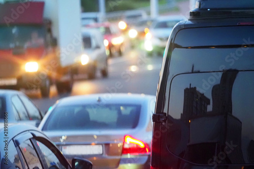 Evening, city traffic jams, city street road. Black van in the foreground