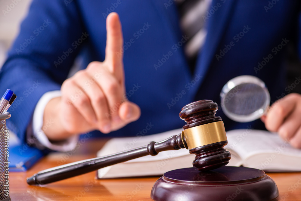 Young male judge sitting in courtroom Young male judge sitting in courtroom