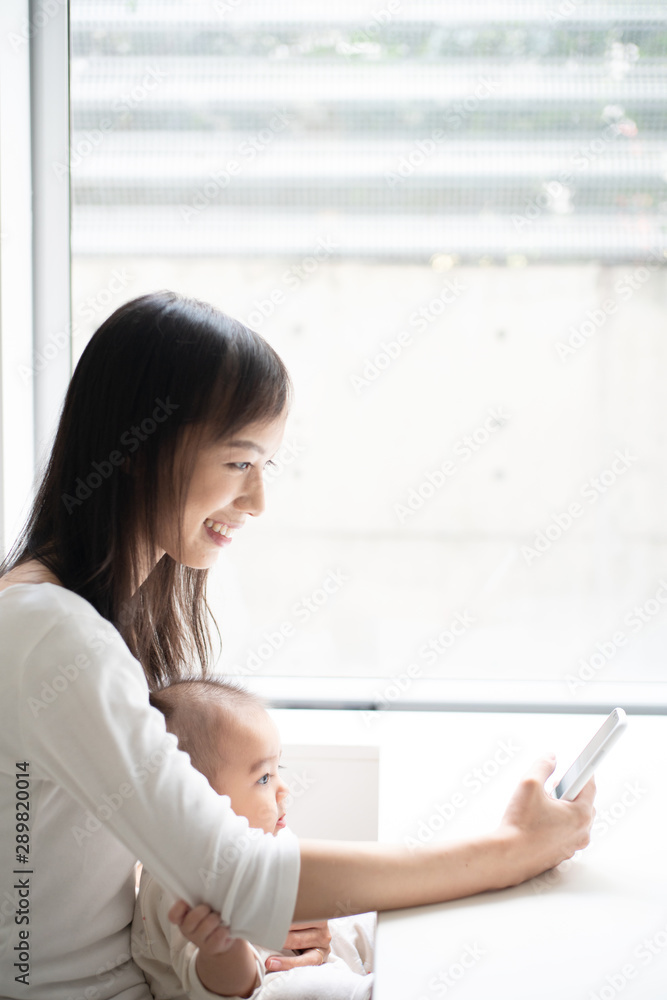 Young mother using smart phone with her baby Young mother using smart phone with her baby