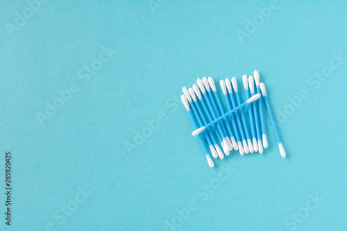 Cotton ear sticks for personal hygiene on blue background. Healthcare tools. Empty space for text.