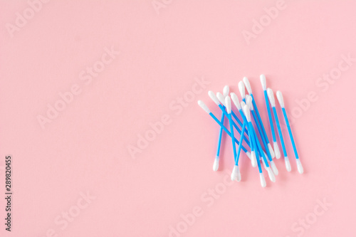 Cotton ear sticks for personal hygiene on pink background. Healthcare tools. Empty space for text.