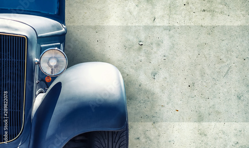 The headlight of the old beautiful car on the background of a concrete wall. Copy space. Concept banners repair, sale of cars.