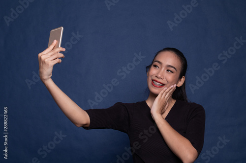 Young Asian woman show thumb up with mobile phone.