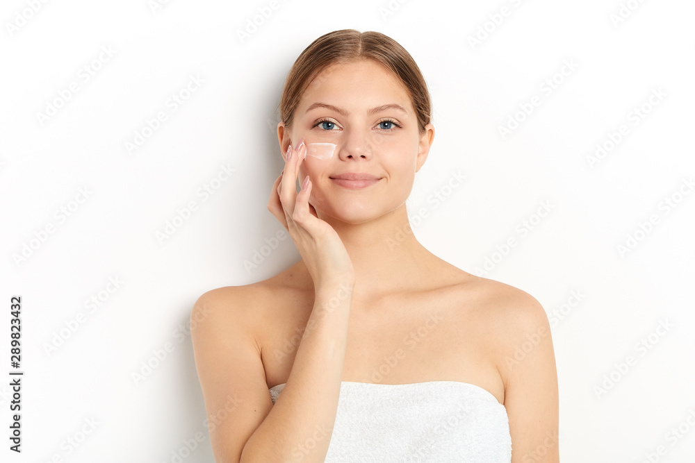lovely girl enjoying new anti-wrinkle cream which helps to reduce, mask, prevent signs of skin aging . close up portrait, isolated white background, studio shot