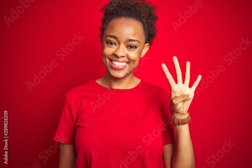 Young beautiful african american woman with afro hair over isolated red background showing and pointing up with fingers number four while smiling confident and happy.