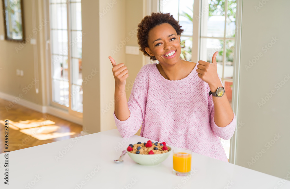 Young african american woman having healthy breakfast in the morning at home success sign doing positive gesture with hand, thumbs up smiling and happy. Looking at the camera with cheerful expression Young african american woman having healthy breakfast in the morning at home success sign doing positive gesture with hand, thumbs up smiling and happy. Looking at the camera with cheerful expression