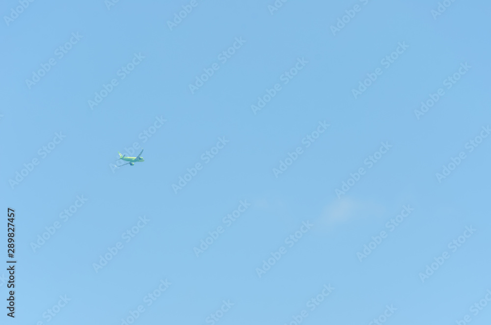 light green plane flies without leaving a trace on the background of the blue sky