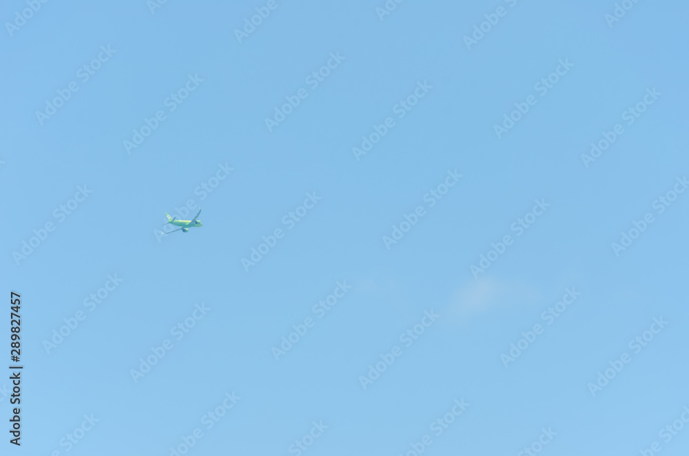 light green plane flies without leaving a trace on the background of the blue sky light green plane flies without leaving a trace on the background of the blue sky