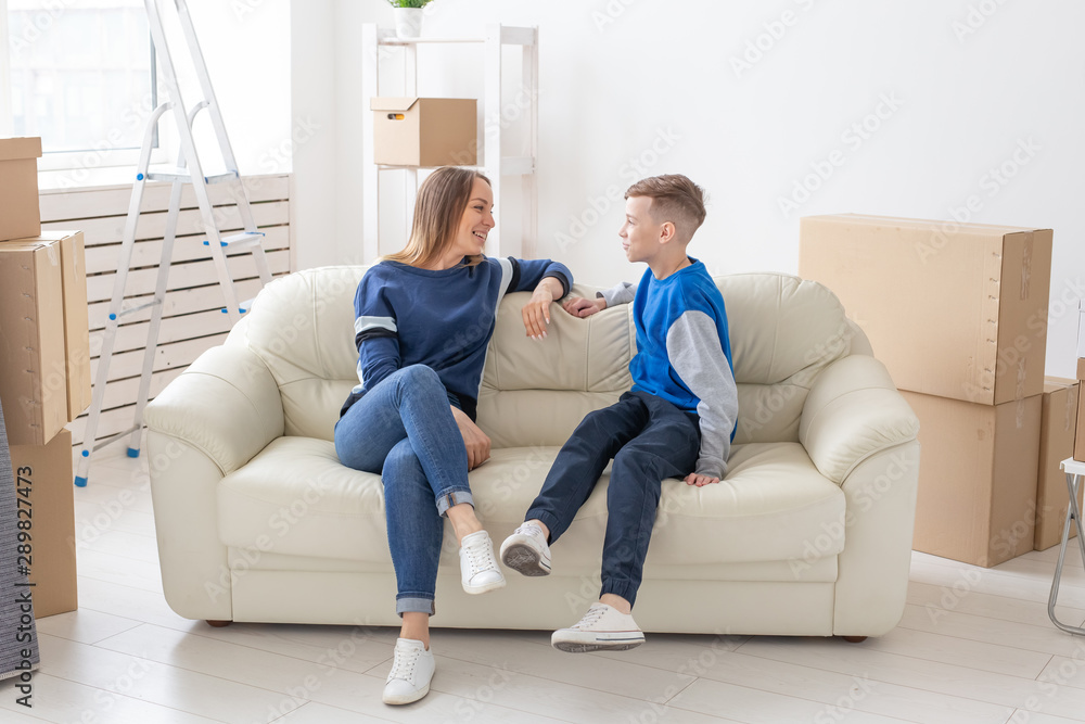Satisfied happy caucasian single mother and son happily communicate discussing the design of the new apartment during the housewarming party. Satisfied happy caucasian single mother and son happily communicate discussing the design of the new apartment during the housewarming party.