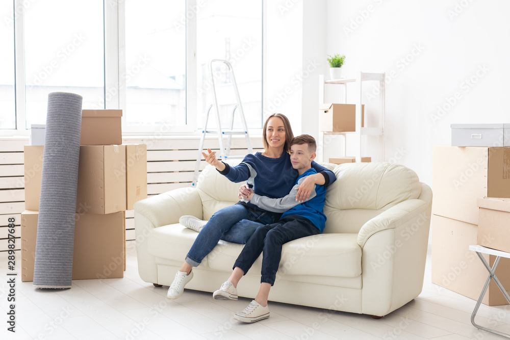 Young cute single mother and son are happy about the move to new house. Concept of housewarming and family space extensions. Young cute single mother and son are happy about the move to new house. Concept of housewarming and family space extensions.