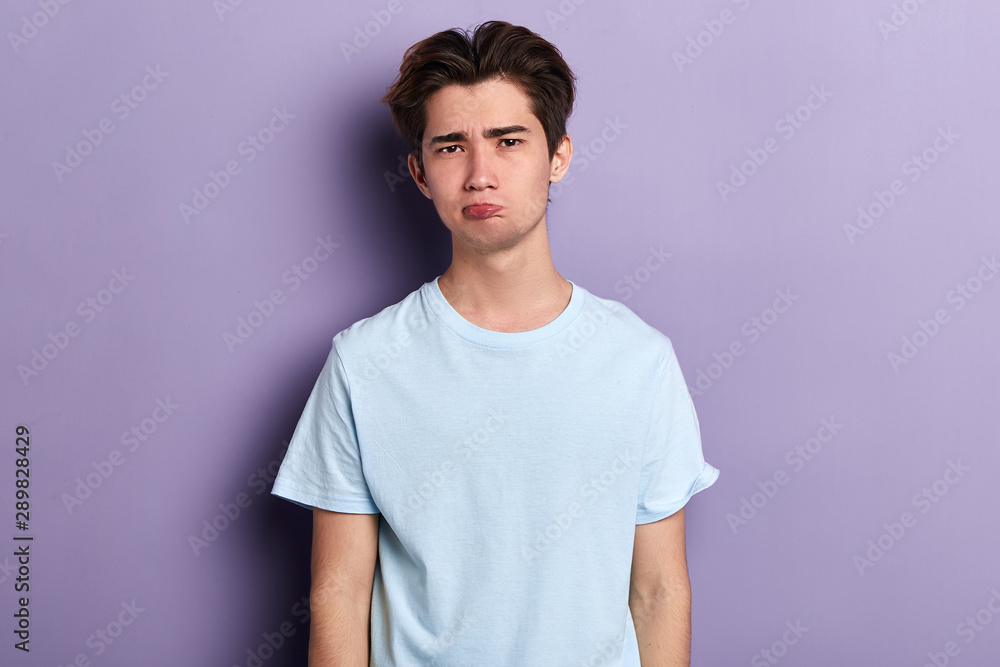 Obraz premium funny young man blowing cheeks, close up portrait, isolated blue background, close up portrait, studio shot. guy making faces