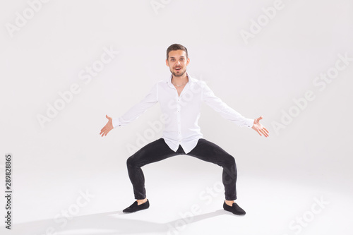 Handsome young man dancing on white background