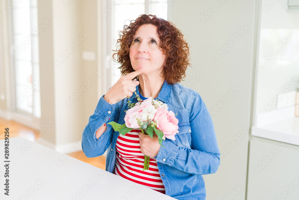 Senior woman holding beautiul bouquet of pink flowers serious face thinking about question, very confused idea Senior woman holding beautiul bouquet of pink flowers serious face thinking about question, very confused idea