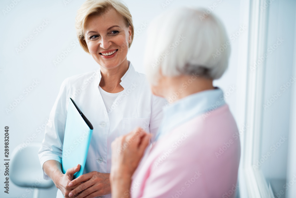 Happy dentist is looking at female patient Happy dentist is looking at female patient