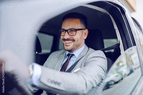 Photos Cheerful caucasian businessman driving himself to work