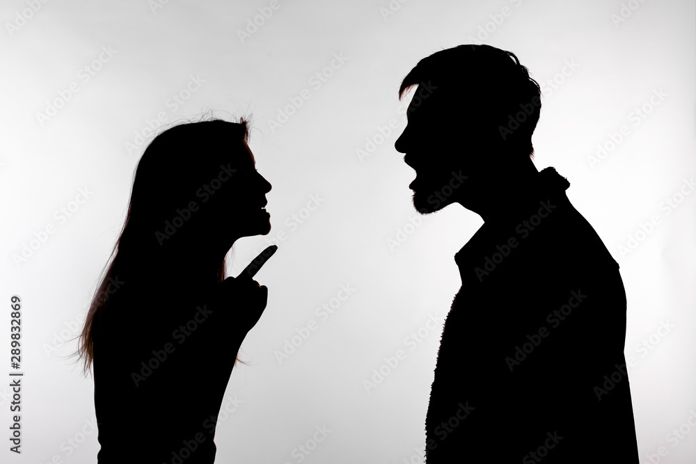 Aggression and abuse concept - man and woman expressing domestic violence in studio silhouette isolated on white background.