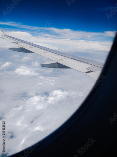 airplane wing in a blue cloudy sky