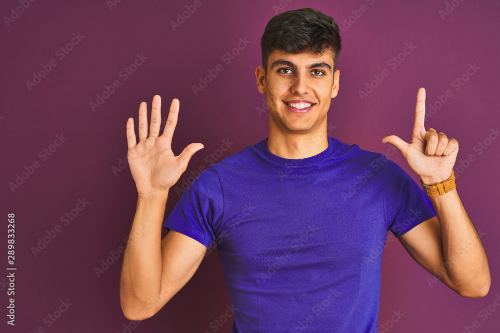 Young indian man wearing t-shirt standing over isolated purple background showing and pointing up with fingers number seven while smiling confident and happy. Young indian man wearing t-shirt standing over isolated purple background showing and pointing up with fingers number seven while smiling confident and happy.