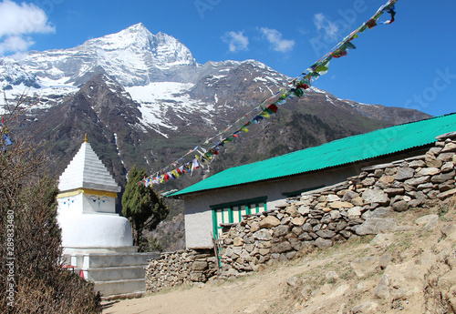 Old typical white Buddhist stupa (chorten) near Phurte village in Himalayas in Nepal. Above is a standard drawing of the eyes of Buddha. Religion, architecture, outdoors, travel and tourism concept. photo