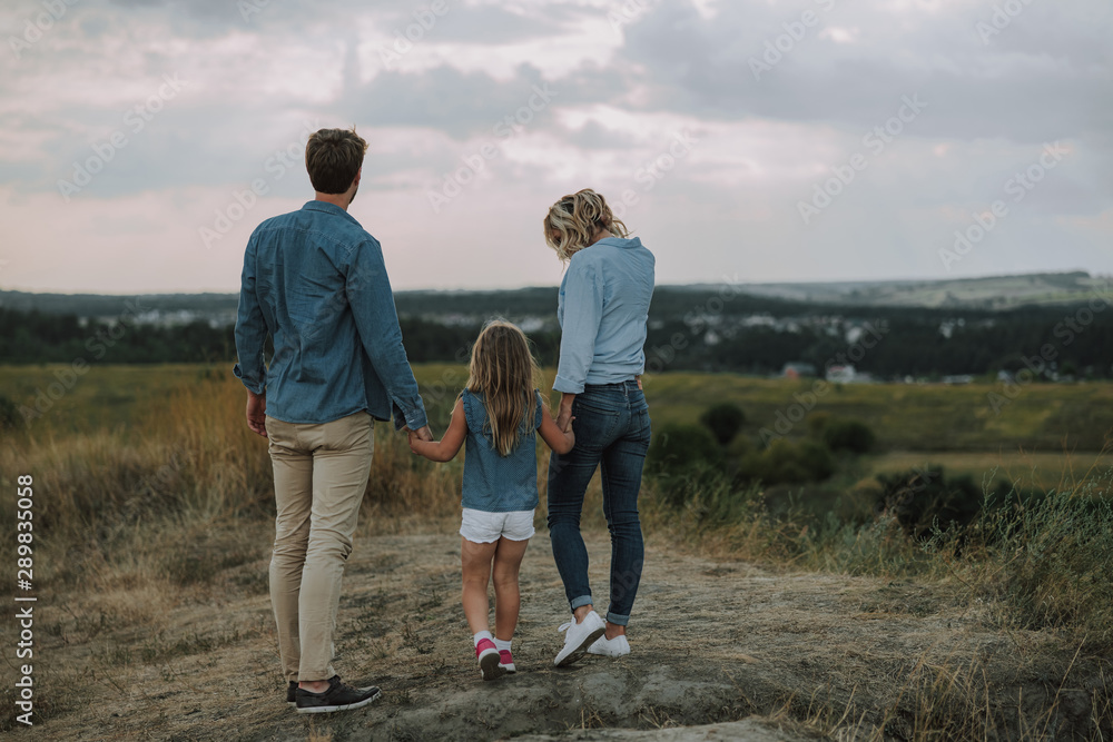 Young famili is standing on the hill Young famili is standing on the hill