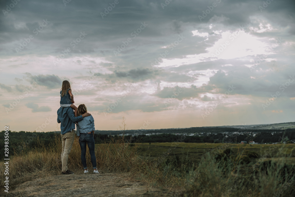 Young family is looking away on the hill Young family is looking away on the hill