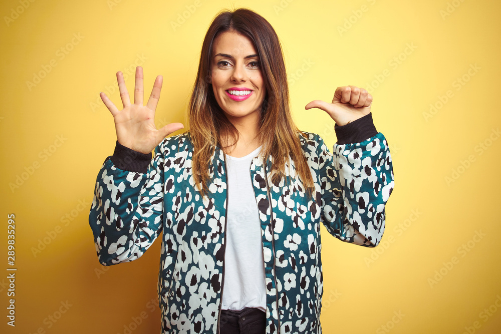 Young beautiful woman wearing casual jacket over yellow isolated background showing and pointing up with fingers number six while smiling confident and happy. Young beautiful woman wearing casual jacket over yellow isolated background showing and pointing up with fingers number six while smiling confident and happy.
