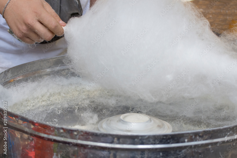 Making white cotton candy in candy floss machine. Sweets for children. Making white cotton candy in candy floss machine. Sweets for children.