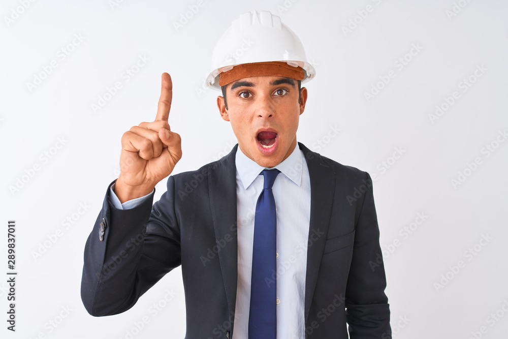 Young handsome architect man wearing suit and helmet over isolated white background pointing finger up with successful idea. Exited and happy. Number one. Young handsome architect man wearing suit and helmet over isolated white background pointing finger up with successful idea. Exited and happy. Number one.