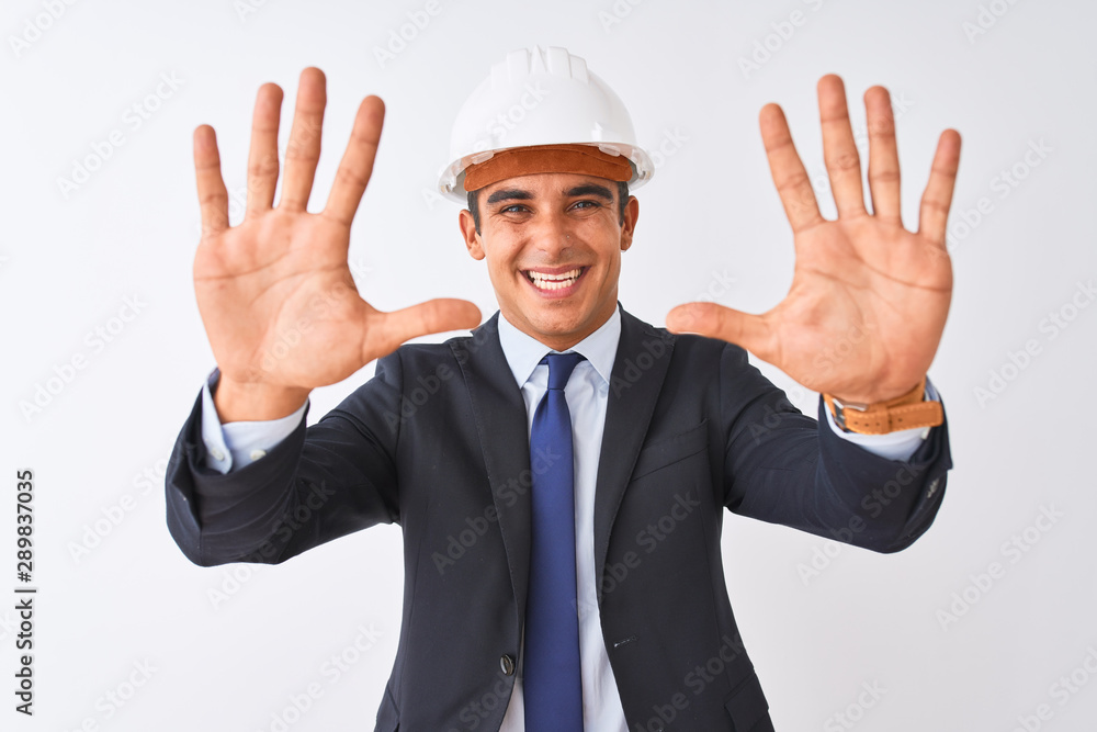 Young handsome architect man wearing suit and helmet over isolated white background showing and pointing up with fingers number ten while smiling confident and happy. Young handsome architect man wearing suit and helmet over isolated white background showing and pointing up with fingers number ten while smiling confident and happy.