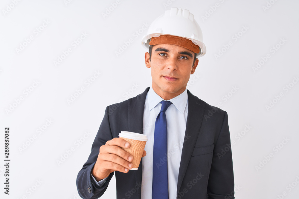 Young handsome architect man wearing helmet drinking coffee over isolated white background with a confident expression on smart face thinking serious Young handsome architect man wearing helmet drinking coffee over isolated white background with a confident expression on smart face thinking serious