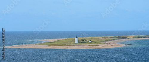 A lighthouse marks the end of a spit of land protruding out into the harbor at Provincetown, Massachusetts. photo