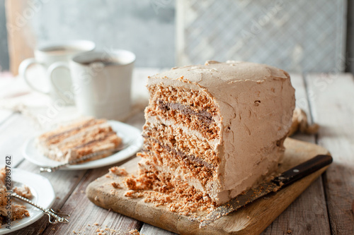 Fototapeta Naklejka Na Ścianę i Meble -  Homemade dacquoise cake with nuts and buttercream on wooden table