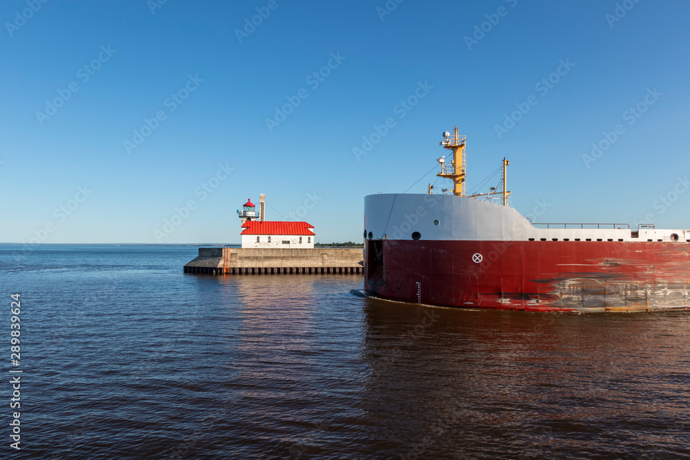 A Ship Passing A Lighthouse On Lake Superior