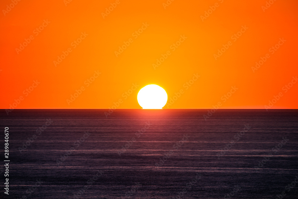 the sun is touching the sea sunset at capo sandalo in the Island of San Pietro, Sardinia