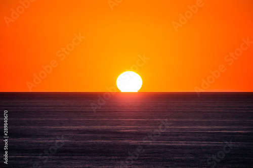Fototapeta Naklejka Na Ścianę i Meble -  the sun is touching the sea sunset at capo sandalo in the Island of San Pietro, Sardinia