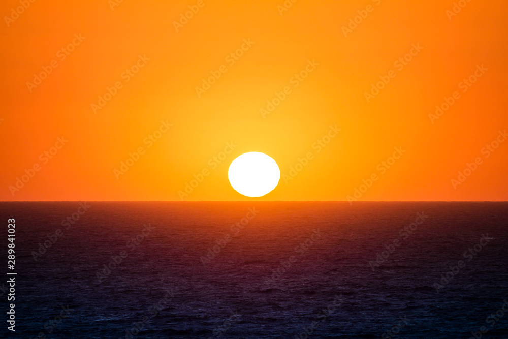 the sun is near the sea at capo sandalo in the Island of San Pietro, Sardinia