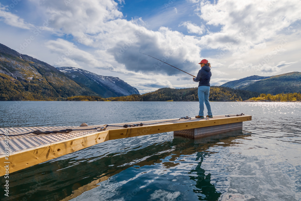 Naklejka premium Woman fishing on Fishing rod spinning in Norway.