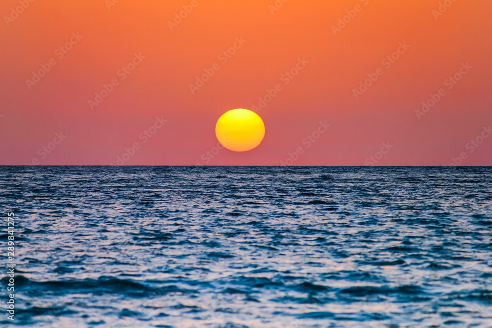 the sun is near the sea at caletta beach in the Island of San Pietro, Sardinia