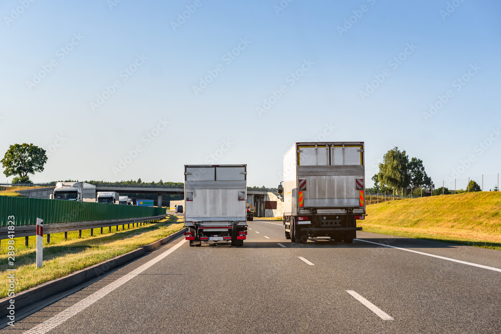 Freight trucks on a highway. Concept of safe driving. Freight trucks on a highway. Concept of safe driving.