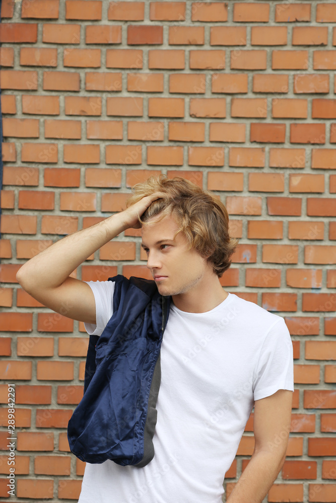 Teenager standing near a brick wall Teenager standing near a brick wall