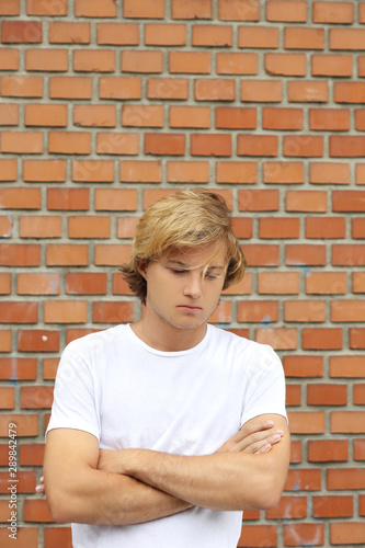 Teenager standing near a brick wall
