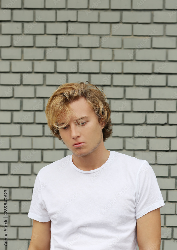 Teenager standing near a brick wall Teenager standing near a brick wall