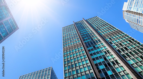 Urban foreshortenings. Office buildings against blue high sunny sky. View up. Vancouver. Canada