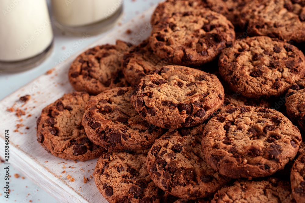 Chocolate chip cookies stacked on a wooden chopping board Chocolate chip cookies stacked on a wooden chopping board
