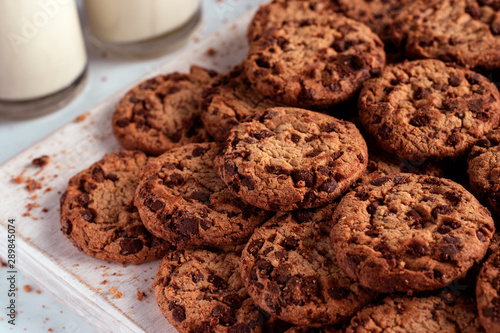 Chocolate chip cookies stacked on a wooden chopping board